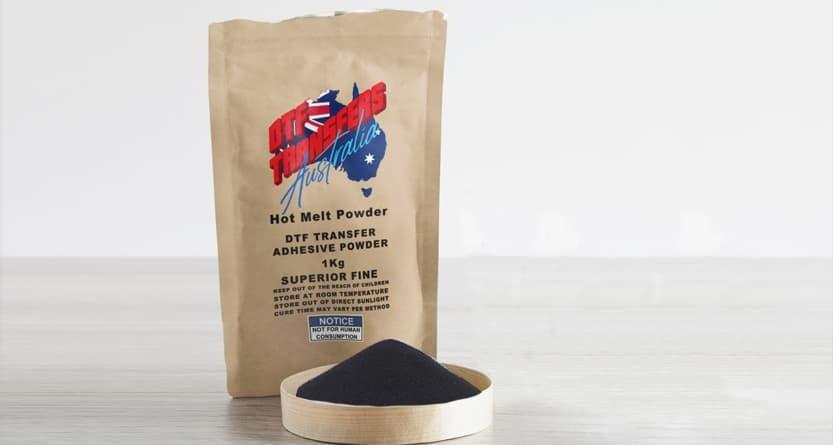 Brown paper resealable bag labeled with "Black DTF Transfer Adhesive Cover" and a small container filled with black powder