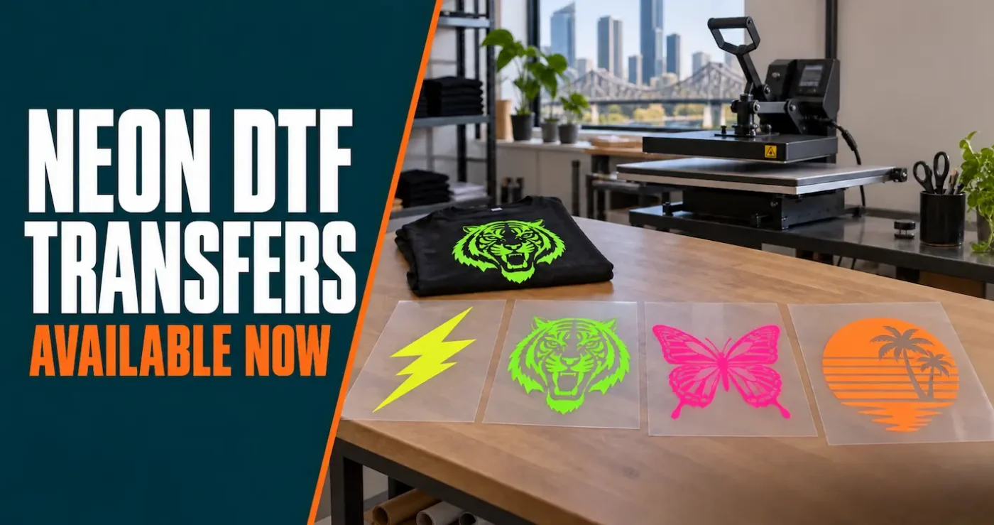 Neon yellow, green, pink and orange DTF transfer sheets displayed beside a heat press